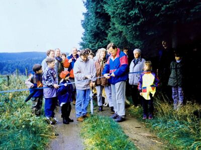 Auf dem Foto sind mehrere Personen zu sehen. Der seinerzeitige 1. Vorsitzende Reinhard Heer und Peter Spitzer (Stadtverwaltung Drolshagen) durchtrennen zur Eröffnung ein Band.