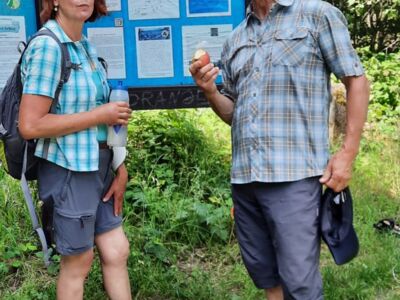 Das Foto zeigt eine Wanderin und einen Wanderer vor der Infotafel am Oberholzklauer Schlag.