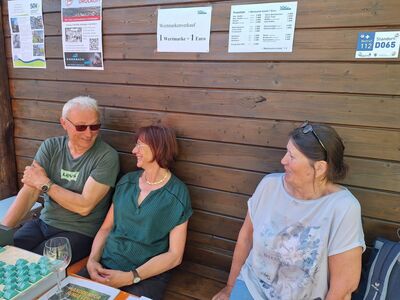 Unser Kassierer mit zwei Frauen sitzend am Wertmarkenverkaufsstand.