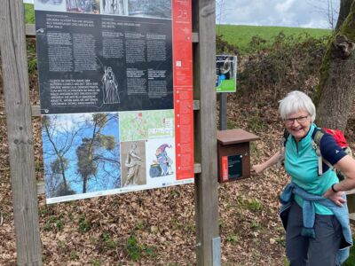 Auf dem Foto ist eine Wanderin an einer Informationstafel zu sehen.