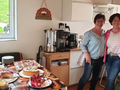 Auf dem Foto sind drei Frauen vom Küchenteam mit dem Kuchenbuffet in der SGV-Hütte zusehen.