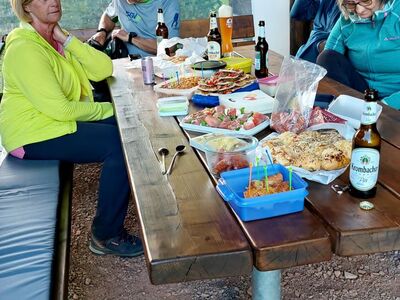 Wanderteilnehmer an der SGV-Hütte sitzend beim Abschlusspicknick