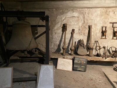Das Foto zeigt mehrere ausrangierte Glockenklöppel und historisches Werkzeug.