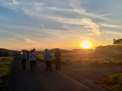 Wanderer im Gegenlicht der aufgehenden Sonne.
