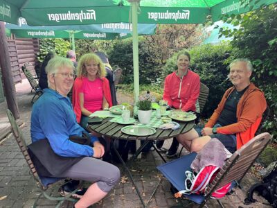 Die Wandergruppe bei der Pause an einem Tisch sitzend.