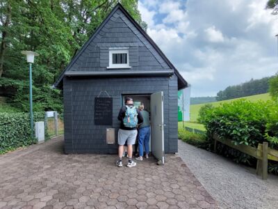 Das Foto zeigt die SGV-Hütte. An der Ausgabetheke stehen zwei Personen und lassen sich bedienen.