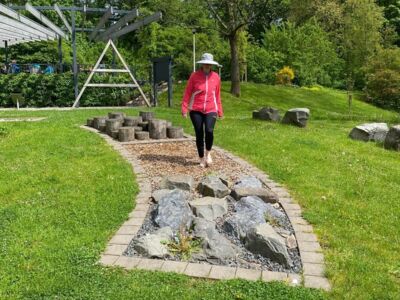 Die Wanderführerin begeht den Barfußpfad im Kurpark.