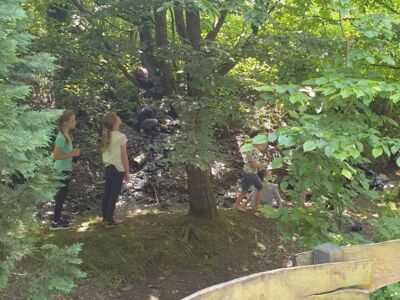 Schulkinder auf dem Hüttengelände. Rund um den Bachlauf gibt es viel zu entdecken.