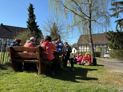Sitzende Wanderteilnehmer bei der Rast im Ortsteil Strünkerhof.