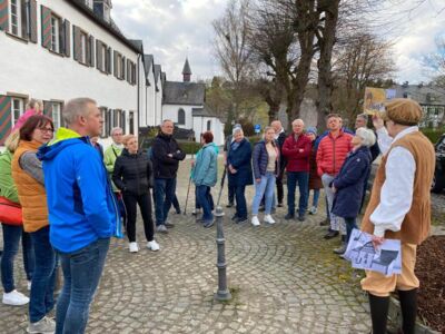 Die Teilnehmer auf dem Platz oberhalb des "Alten Klosters" lauschen den Erläuterungen des Stadtführers.