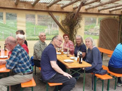 Auf dem Foto sitzen Frauen und Männer an Festzeltgarnituren bei Kaffee, Kuchen und Kaltgetränken.