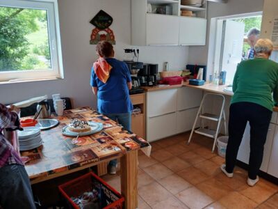 Zwei Frauen des Küchenteams bei der Ausgabe von Kaffee, Kuchen und Kaltgetränken.