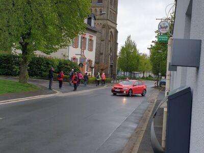 Wandergruppe bei der Wanderung durch eine Ortschaft. In Hintergrund eine Kirche.