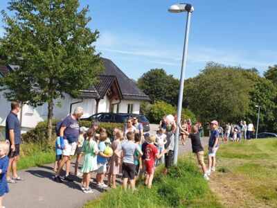 Schulkinder und Eltern sammeln sich am Dorfhaus Benolpe.