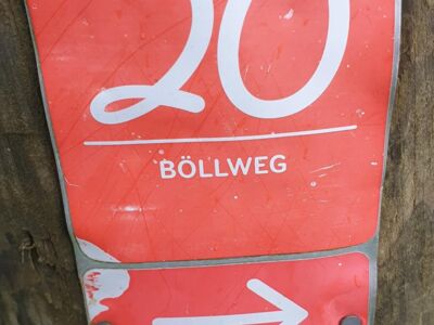 Rotes Wegweiserschild mit weißer Schrift des Böllweges