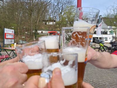 Die Mountainbiker stoßen mit Biergläsern an.